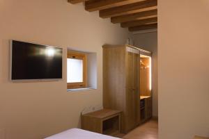 a bedroom with a flat screen tv on the wall at Hotel Sesmones in Lodi