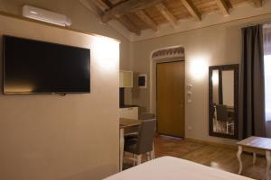 a living room with a television on a wall at Hotel Sesmones in Lodi