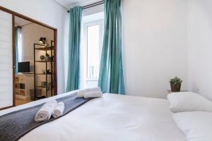 a bedroom with a large white bed with towels on it at 1 bedroom 1 bathroom furnished - Chueca - bright in downtown area - MintyStay in Madrid