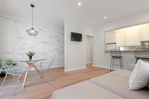 a living room with a table and chairs and a kitchen at MintyStay - 1BD Chueca in Madrid