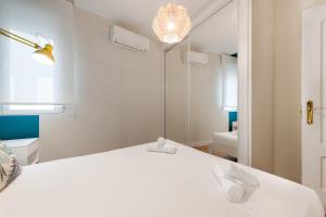 MintyStay - 1BD Chueca في مدريد: غرفة نوم بسرير ابيض ومرآة