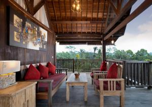 a porch with a couch and chairs on a deck at Abian Taksu Suite & Villas in Tegalalang