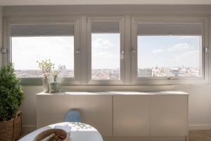 uma cozinha com três janelas e uma mesa em 1 bedroom 1 bathroom furnished - Justicia - Incredible views - MintyStay em Madri