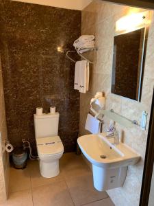 Łazienka z białą toaletą i umywalką w obiekcie Kaplica Hotel w mieście Famagusta