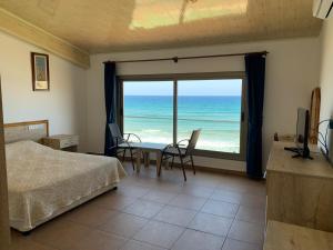 a bedroom with a bed and a view of the ocean at Kaplica Hotel in Famagusta