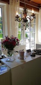 eine Küche mit einem Tisch mit Kuchen und Blumen darauf in der Unterkunft Garni Villa Tyrol - Adults Only in Meran