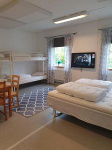 a bedroom with two bunk beds and a table and chairs at Torsby Vandrarhem in Torsby