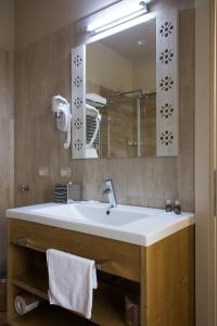 uma casa de banho com um lavatório branco e um espelho. em Hotel Sesmones em Lodi