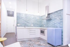 a kitchen with a white refrigerator and blue tiles at Fancy One-bedroom La Latina in Madrid