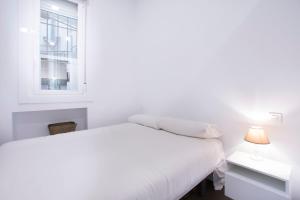 a white bedroom with a bed and a window at Fancy One-bedroom La Latina in Madrid