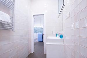 bagno bianco con lavandino e specchio di Fancy One-bedroom La Latina a Madrid