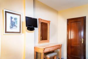 Televízia a/alebo spoločenská miestnosť v ubytovaní Hotel El Cruce Chauchina