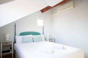 a bedroom with a white bed with a green headboard at Cozy one-bedroom penthhouse La Latina in Madrid