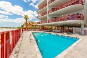 ein Schwimmbad vor einem Gebäude mit einem Hotel in der Unterkunft Luxury Direct Beachfront Views - Crimson #201 in St Pete Beach
