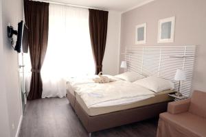 a bedroom with a bed and a large window at Hotel Baden in Bonn