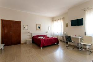 a bedroom with a red bed and a desk at Porta della Musa in Ascoli Piceno