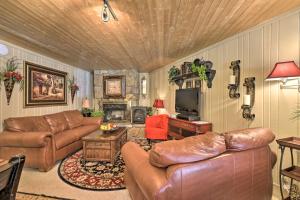 a living room with leather couches and a television at Walk to Ski and Trails All-Season Angel Fire Escape in Angel Fire