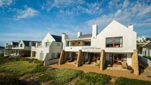 una grande casa bianca con un cartello sopra di Paternoster Dunes Boutique Guesthouse a Paternoster