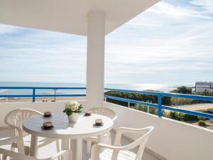 una mesa y sillas en un balcón con vistas al océano en Apartamentos Playa Cargador, en Alcossebre