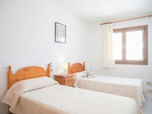um quarto com 2 camas e uma janela em Apartamentos Playa Cargador em Alcossebre