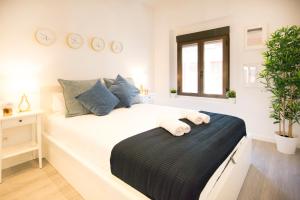 1 dormitorio con 1 cama blanca grande con reloj en la pared en 1 bedroom 1 bathroom- MintyStay - Plaza de San Idelfonso, en Madrid