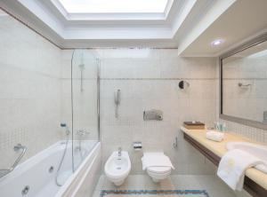 
a bathroom with a toilet, sink, and shower at Atrium Palace Thalasso Spa Resort And Villas in Kalathos

