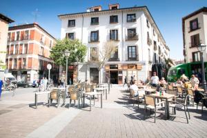 Un groupe de personnes assises à des tables dans une rue de la ville dans l'établissement 1 bedroom 1 bathroom- MintyStay - Plaza de San Idelfonso, à Madrid