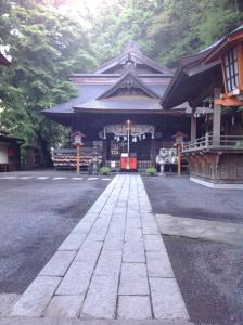 un temple japonais avec une passerelle devant lui dans l'établissement Guest house Fujinoyado Akebono - Vacation STAY 92428, à Fujiyoshida