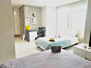 een slaapkamer met 2 bedden en een bureau met een hoed erop bij ARA Palace Hotel in Jeju-stad