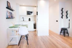 een keuken met witte kasten en een tafel en stoelen bij 1 bedroom 1 bathroom furnished - Salamanca - executive style - MintyStay in Madrid