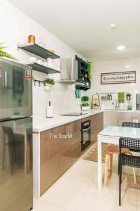 a kitchen with a white counter and a table at The Scarlet @ Sunway Gandaria in Kampong Sungai Ramal Dalam