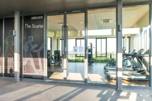 a gym with glass doors and treadmills in a building at The Scarlet @ Sunway Gandaria in Kampong Sungai Ramal Dalam