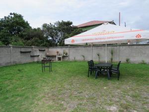 a patio with a table and an umbrella and chairs at Apartments and cottages in Batumi in Batumi