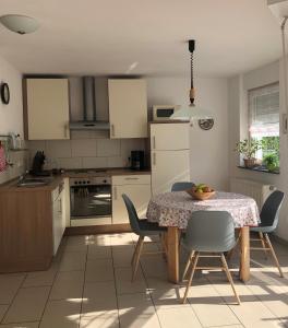 uma cozinha com mesa e cadeiras e uma cozinha com armários brancos em Haus Ostermann em Cochem