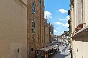 Un gruppo di persone che camminano lungo una strada accanto a un edificio di San Giuseppe Nido a Firenze