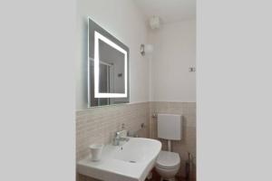 W łazience znajduje się umywalka, toaleta i lustro. w obiekcie San Giuseppe Nido we Florencji