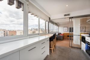 een keuken met witte kasten en grote ramen bij 2 bedroom 2 bathroom furnished - Salamanca - bright & Stylish - MintyStay in Madrid