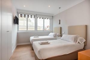 een slaapkamer met 2 bedden en een raam bij 2 bedroom 2 bathroom furnished - Salamanca - bright & Stylish - MintyStay in Madrid