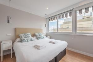 een slaapkamer met een groot wit bed en een raam bij 2 bedroom 2 bathroom furnished - Salamanca - bright & Stylish - MintyStay in Madrid