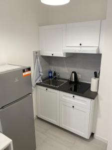 una cucina bianca con lavandino e frigorifero di Stadio 1 - Appartamenti locazione turistica Verona a Verona