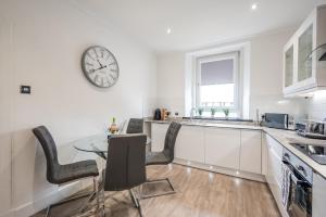 a kitchen with a table and a clock on the wall at Casa Fresa - Union Heights in Dundee