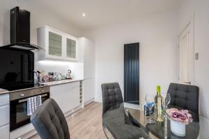 cocina y comedor con mesa de cristal y sillas en Casa Fresa - Union Heights, en Dundee