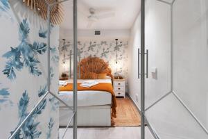 1 dormitorio con 1 cama con sábanas de color naranja y papel pintado con motivos florales en 2 bedrooms 1 bathroom furnished - Justicia - Executive style - MintyStay en Madrid