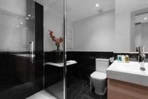 a bathroom with a toilet and a glass shower at 2 bedrooms 1 bathroom furnished - Justicia - Executive style - MintyStay in Madrid