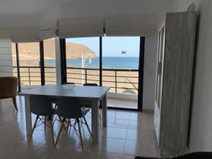 a table and chairs in a room with a view of the ocean at Brisa Mar in Gran Tarajal