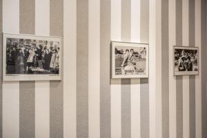 three framed pictures on a striped wall at Marta Inn in Rome