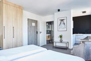 sypialnia z białym łóżkiem i stołem w obiekcie Silesia Apartments w mieście Katowice