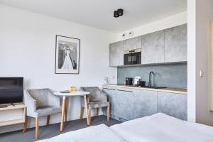 a kitchen with a table and two chairs in a room at Silesia Apartments in Katowice