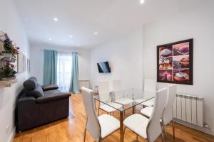 ein Esszimmer mit einem Glastisch und weißen Stühlen in der Unterkunft Central and modern- 2 bedrooms 1 bathroom - MintyStay- Sol in Madrid