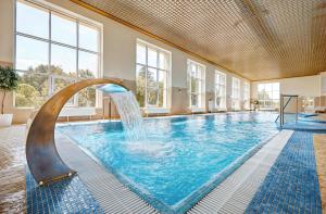una piscina con una fuente de agua en un edificio en Medical&Spa Resort Alfa Radon, en Baraviki